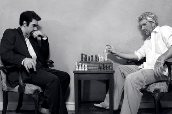 Image of a evil person and a saintly person playing chess.